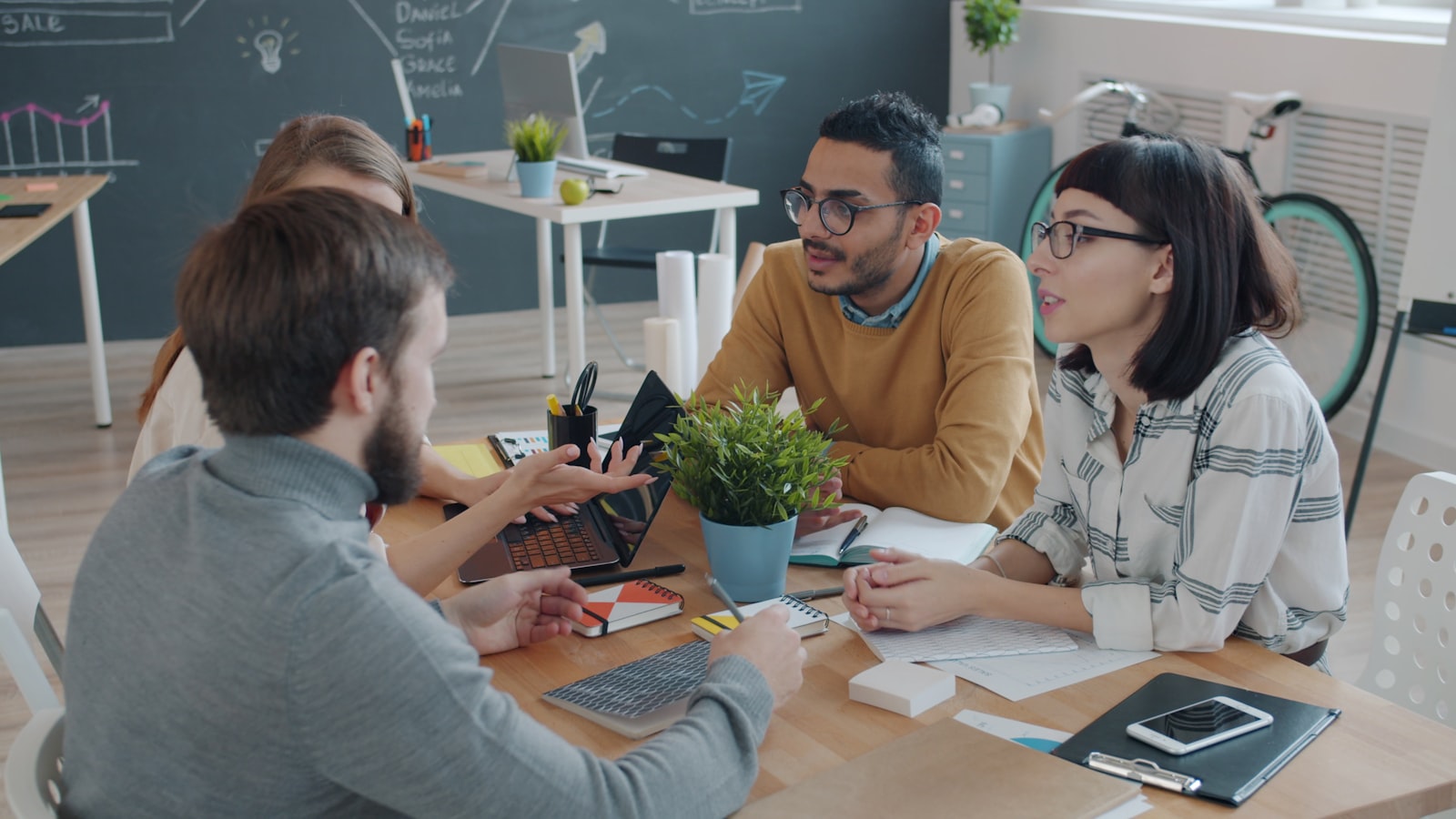 Diverse team collaborating and celebrating a win in a modern office